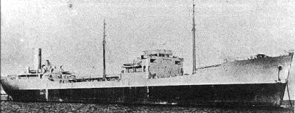 Kornigt svartvitt arkivfoto av en tanker från sidan, med bryggan i mitten, två master och skorstenen akterut.